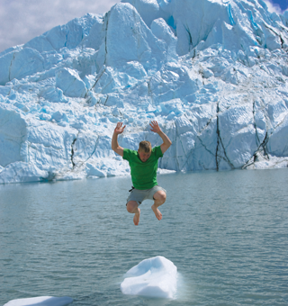 An explorer jumping beside a glacier
